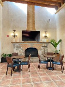 a living room with tables and a fireplace at Hotel Boutique La Granja in Tequisquiapan