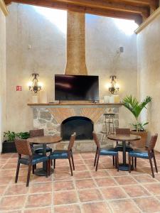 - un salon avec des tables et une cheminée dans l'établissement Hotel Boutique La Granja, à Tequisquiapan
