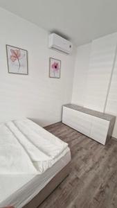 um quarto branco com uma cama e uma cómoda em Central Cute City Apartment w Free Parking em Ljubljana