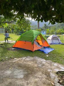 an orange and green tent sitting on the grass at Apartamentovistadelrio2 in Orocovis