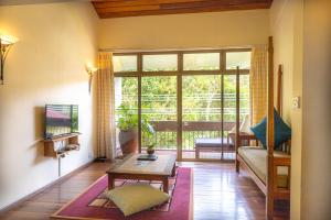 a living room with a couch and a table at Sutera Sanctuary Lodges At Kinabalu Park in Kampong Kundassan