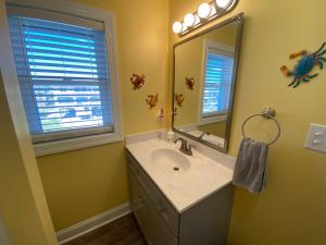 a bathroom with a sink and a mirror at 2 if by Sea- East Unit in Emerald Isle