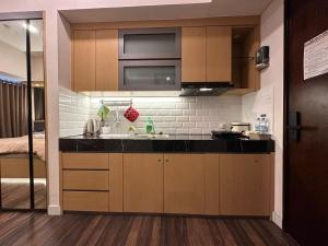 a kitchen with a sink and a microwave at LUXURY CASA DE PARCO Apartment Near AEON MALL, THE BREEZE, ICE BSD in Tangerang