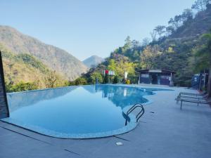 Shivpuri的住宿－HOA Resorts - Mountain View with Infinity Pool，一座大游泳池,后面是群山