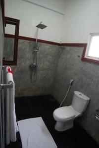 a bathroom with a toilet and a shower at Turtle Bay Beach Resort in Mirissa