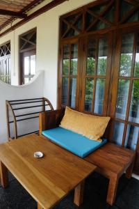 a room with a bench and a table and windows at Turtle Bay Beach Resort in Mirissa