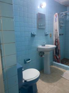 a blue tiled bathroom with a toilet and a sink at Habitación a media cuadra de la playa. in Mazatlán