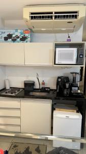 a kitchen with a microwave and a counter top at Flat Suites em Hotel de Luxo in Maceió