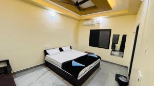 a bedroom with a bed and a flat screen tv at Greenstone Resort Hampi in Hampi