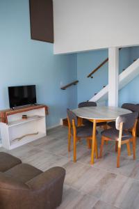 ein Wohnzimmer mit einem Tisch und Stühlen sowie einem TV in der Unterkunft Alfa & Omega in Dina Huapi