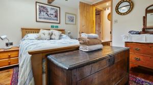 ein Schlafzimmer mit einem Bett und einer Holzkommode in der Unterkunft Keepers Cottage in Wool