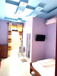 Ấp Tân Phú (1)的住宿－Khách Sạn Như Ý，一间卧室设有紫色墙壁和蓝色天花板