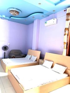 Habitación con 2 camas y techo azul. en Khách Sạn Như Ý, en Ấp Tân Phú (1)