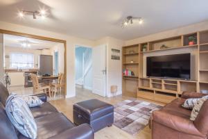 a living room with a couch and a flat screen tv at Modern and Comfy 3 bed Cambridge House in Cambridge