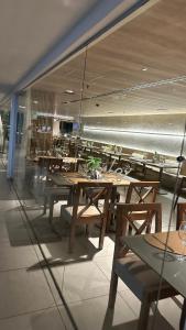 a restaurant with tables and chairs in a room at Flat Suites em Hotel de Luxo in Maceió