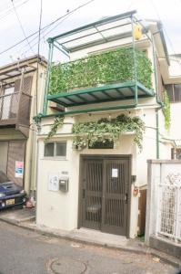 un edificio con una puerta con plantas. en 滝野苑, en Tokio