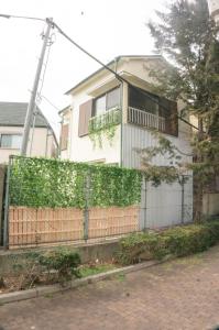una casa con una valla delante de ella en 滝野苑, en Tokio