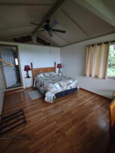 a bedroom with a bed and a ceiling fan at Banyan Tree Sanctuary Guest House in Kailua-Kona