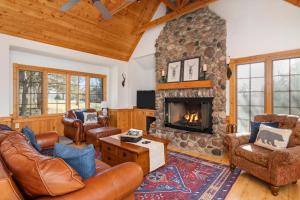 The Lodge, 'North Woods' style, boutique Galena Getaway! في غالينا: غرفة معيشة مع أثاث من الجلد ومدفأة حجرية
