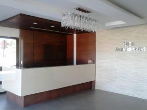 a lobby with a chandelier in a building at Hotel Areias Brancas in Rosário do Sul
