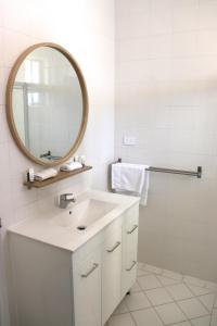 Baño blanco con lavabo y espejo en The Anglers Inn en Wallaroo