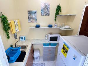eine kleine Küche mit einer Spüle und einer Mikrowelle in der Unterkunft Elizabeth Retreat - Island time in Ocho Rios