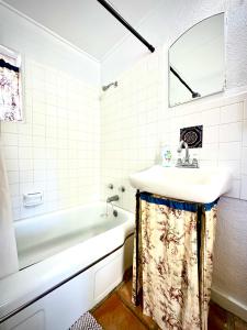 a white bathroom with a sink and a bath tub at The Casita in Raton