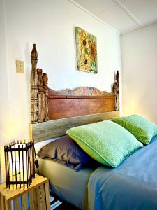 Bett mit einem Kopfteil aus Holz in einem Schlafzimmer in der Unterkunft The Casita in Raton