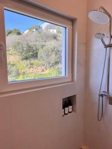 a window in a bathroom with a shower at Haroupia Hillside Villa in Kalymnos