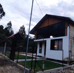 una pequeña casa con una valla delante de ella en Cabaña en Oxapampa, en Oxapampa