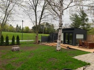 uma cabana preta com uma árvore num parque em Lovely walkout basement em Mississauga