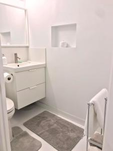 a white bathroom with a sink and a toilet at Lovely walkout basement in Mississauga