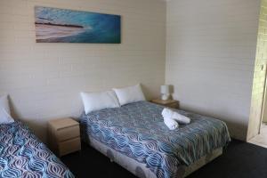 1 dormitorio con 1 cama con 2 almohadas blancas en The Anglers Inn, en Wallaroo