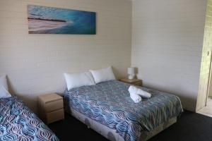 a bedroom with a bed with two white pillows at The Anglers Inn in Wallaroo