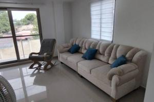 a living room with a large couch with blue pillows at Apartamento Amueblados Jireh in San Onofre