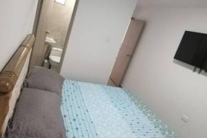 - une petite chambre avec un lit et une salle de bains dans l'établissement Apartamento Amueblados Jireh, à San Onofre