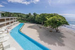 a resort with a swimming pool next to a beach at Increíble departamento en Bolongo punta de mita in Higuera Blanca