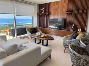 a living room with a couch and a tv and a table at Increíble departamento en Bolongo punta de mita in Higuera Blanca