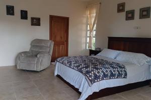 1 dormitorio con 1 cama y 1 silla en Alojamiento entero Galápagos, Puerto Ayora, Bellavista, Ecuador, en Bellavista