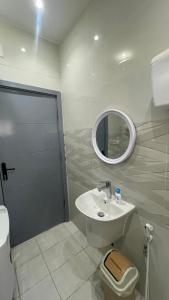 bagno con lavandino, servizi igienici e specchio di شقة غرفتين وصاله a Al ‘Uqūl