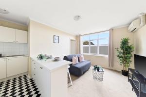 a kitchen and living room with a couch and a table at A Comfy & Cozy Apt in Clifton Hill FREE Parking in Melbourne