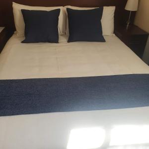 een bed met zwarte en witte kussens erop bij Thokgamo Bed and Breakfast in Kanye