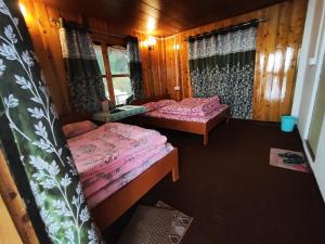 una habitación con 2 camas en una cabaña en Mount View Homestay Sittong, en Mangpu