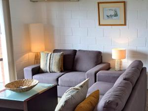 - un salon avec un canapé et une table dans l'établissement Blue Seas Holiday Villas, à Scamander
