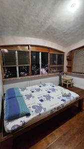 Cama grande en habitación con ventanas en Boyers island camp site, en San Vicente