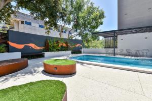 a swimming pool with tables and chairs next to a building at Aurea Hotel Perth Kings Park in Perth