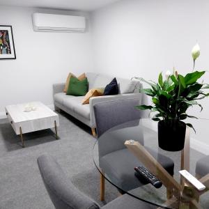 a living room with a couch and a table at City Fringe Apartment with garage in Wellington