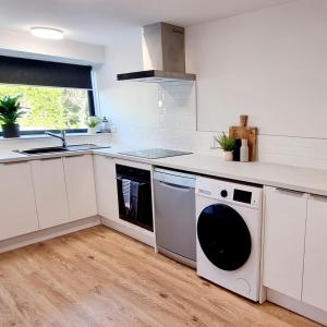 a kitchen with a washing machine and a sink at City Fringe Apartment with garage in Wellington
