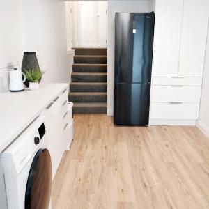 a kitchen with a refrigerator and a staircase at City Fringe Apartment with garage in Wellington