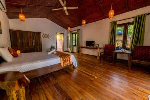 Dugong Resort Phu Quoc في فو كووك: غرفة نوم بسرير وارضية خشبية